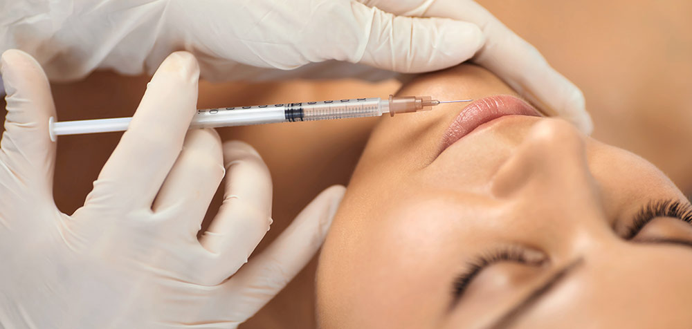 Image of a woman getting a lip filler injection.
